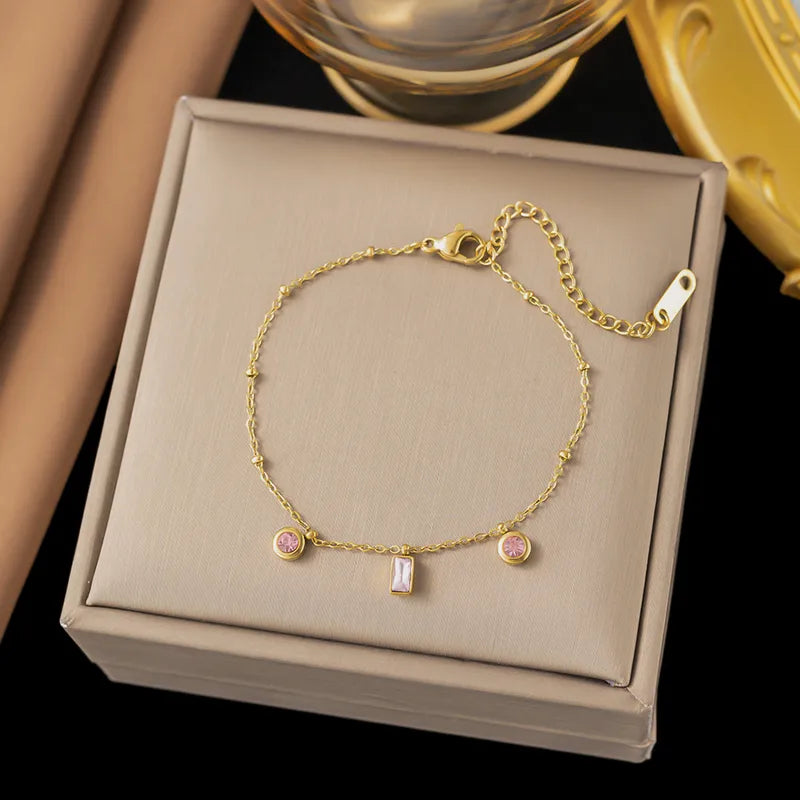Fijn goudkleurige armband met roze steentjes
