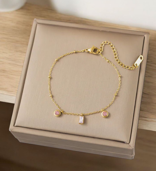 Fijn goudkleurige armband met roze steentjes