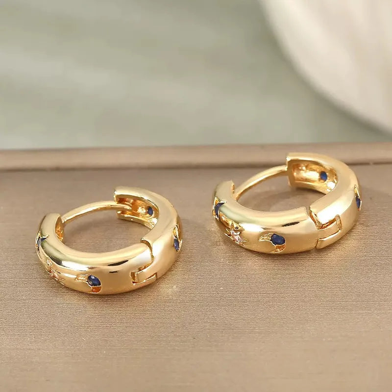 Goudkleurige ooringen met blauw witte zirconia