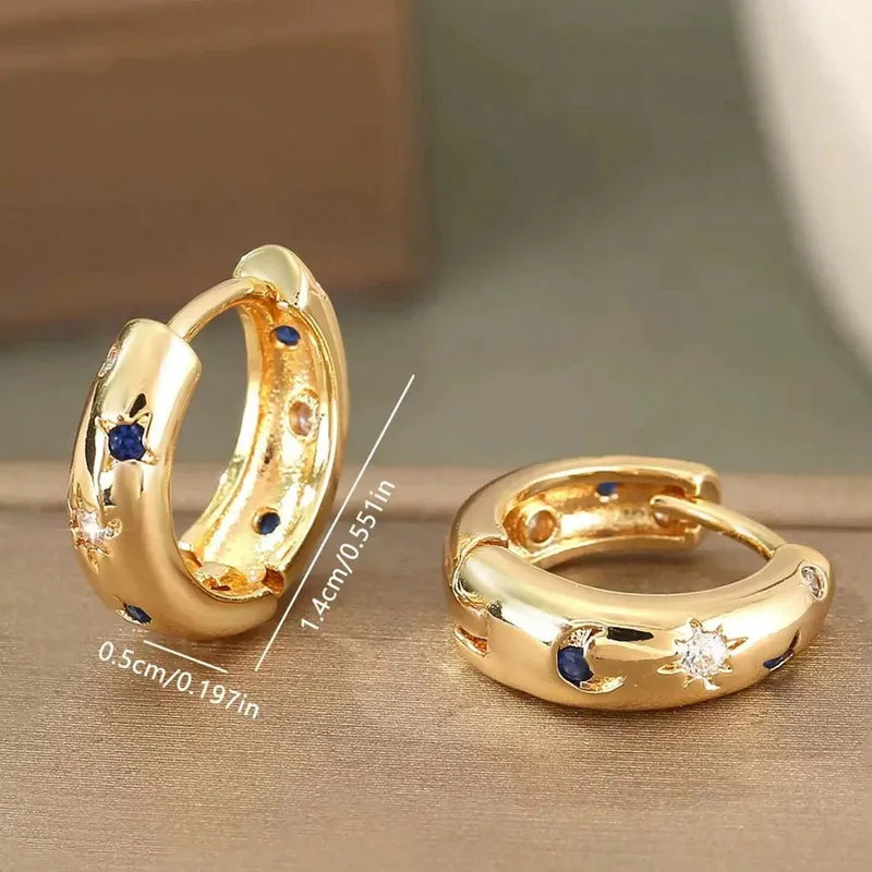 Goudkleurige ooringen met blauw witte zirconia